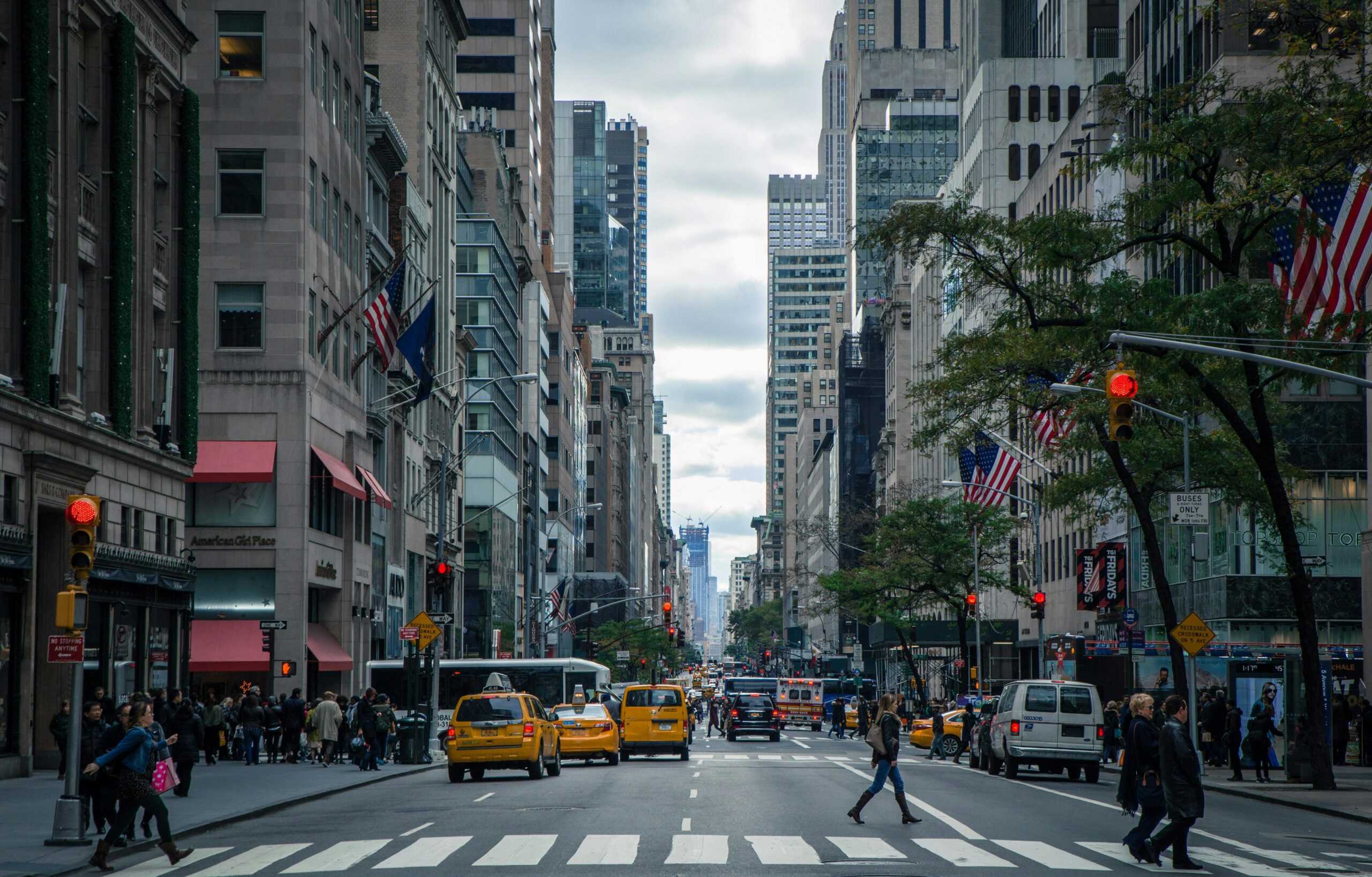 Vibrant street view of New York City with pedestrians, yellow cabs, and skyscrapers.