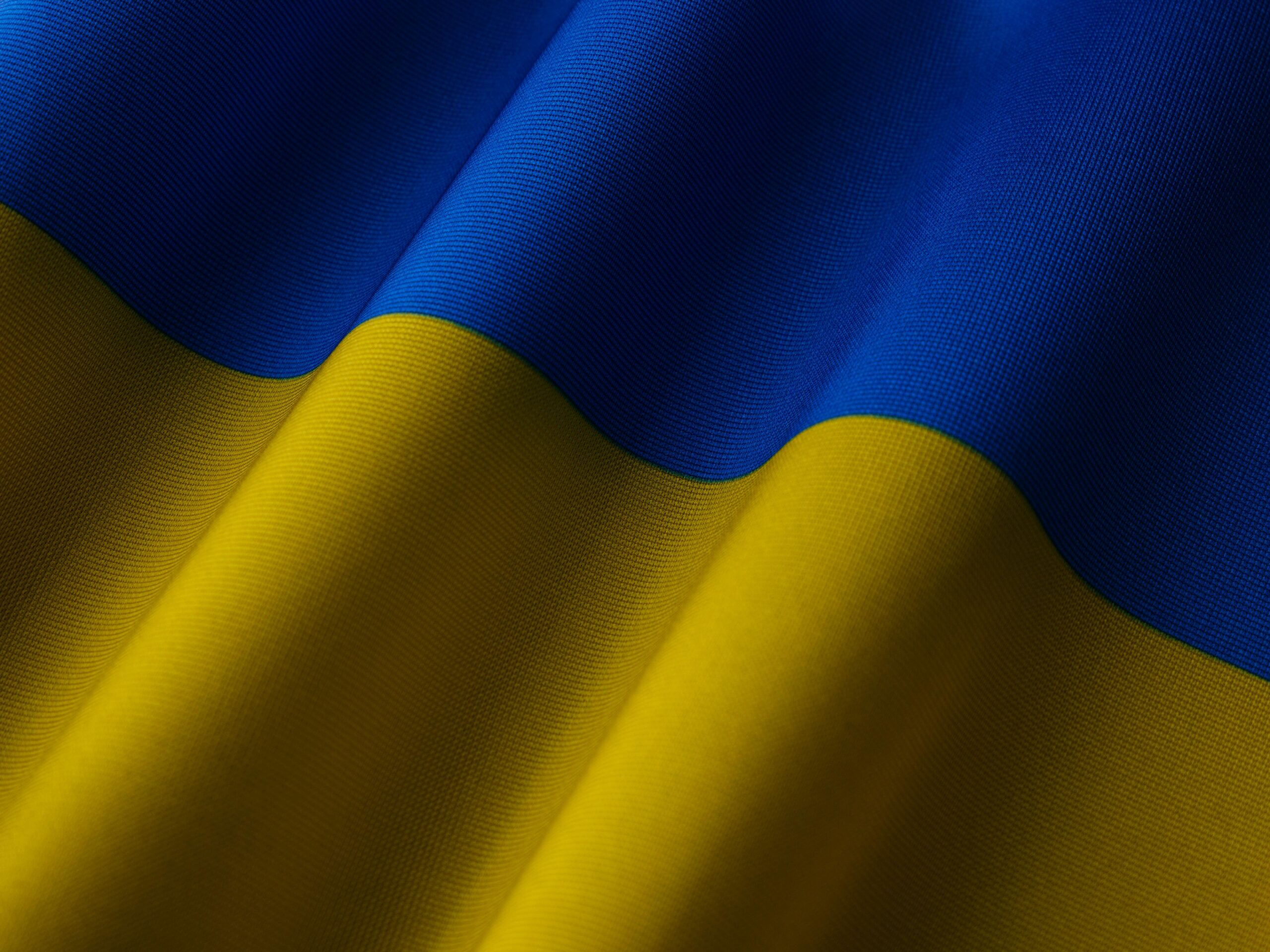 Close-up of the Ukrainian flag showing vibrant blue and yellow waves.