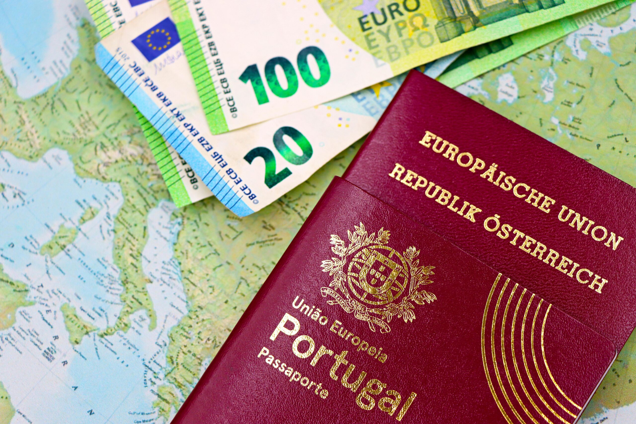 Portugal and Austria passports displayed with Euro currency notes on European map background.