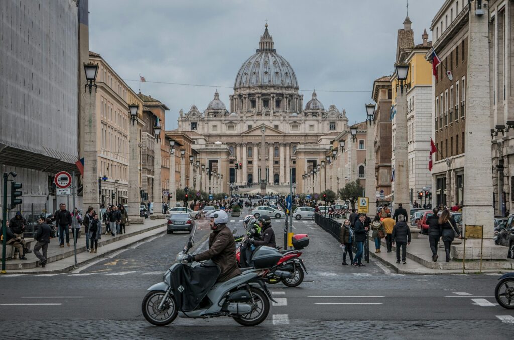 St. Peter's Basilica view with vibrant street life, Rome.