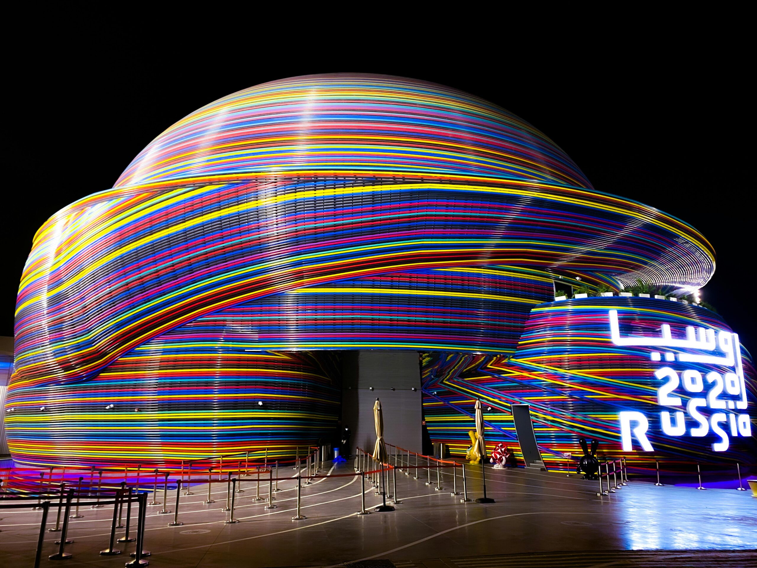 Vibrant neon-lit Russian Pavilion at Dubai Expo 2020, showcasing modern architecture.