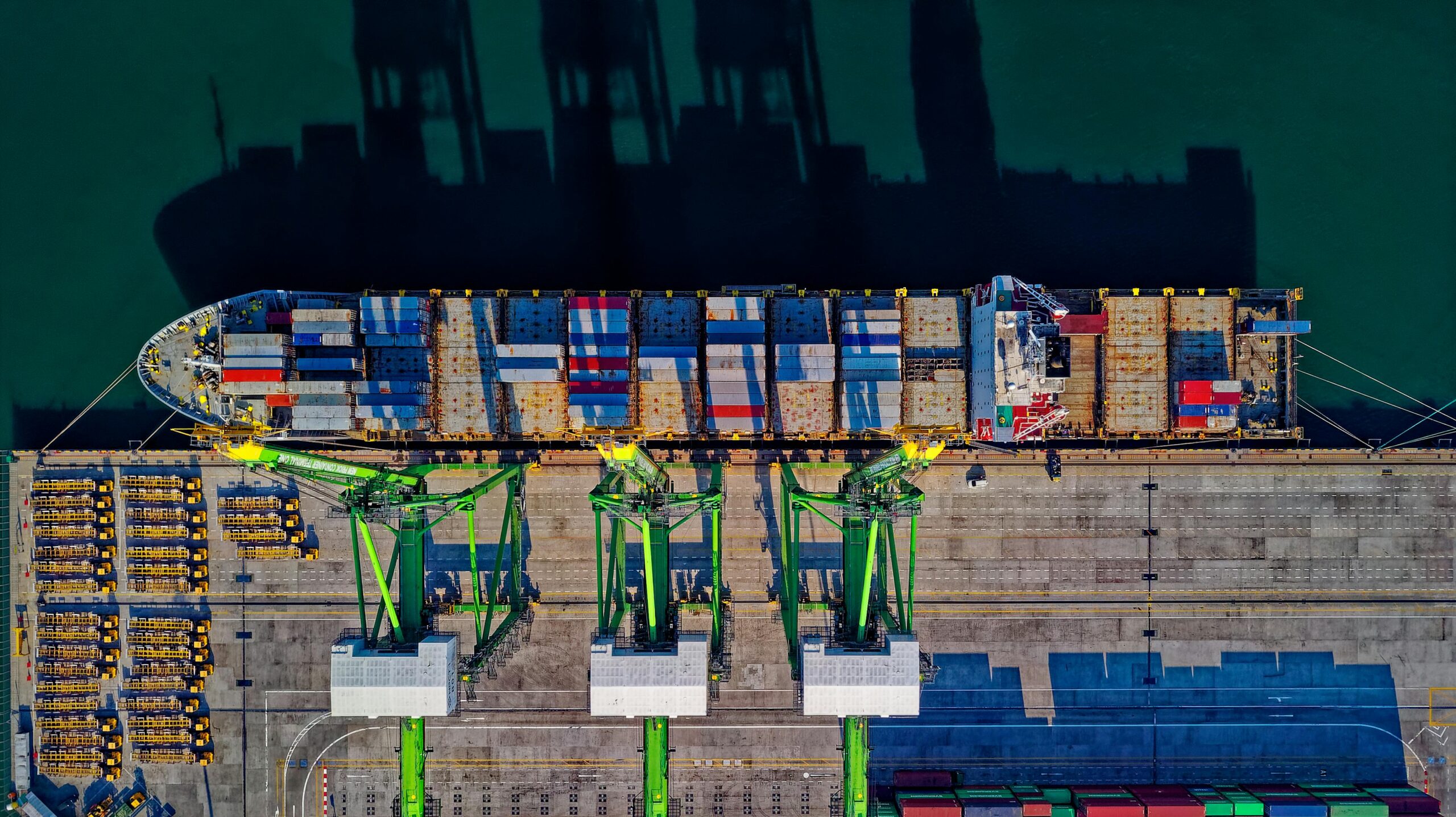 High angle aerial view of a cargo ship at a bustling port in Jakarta, showcasing global trade.