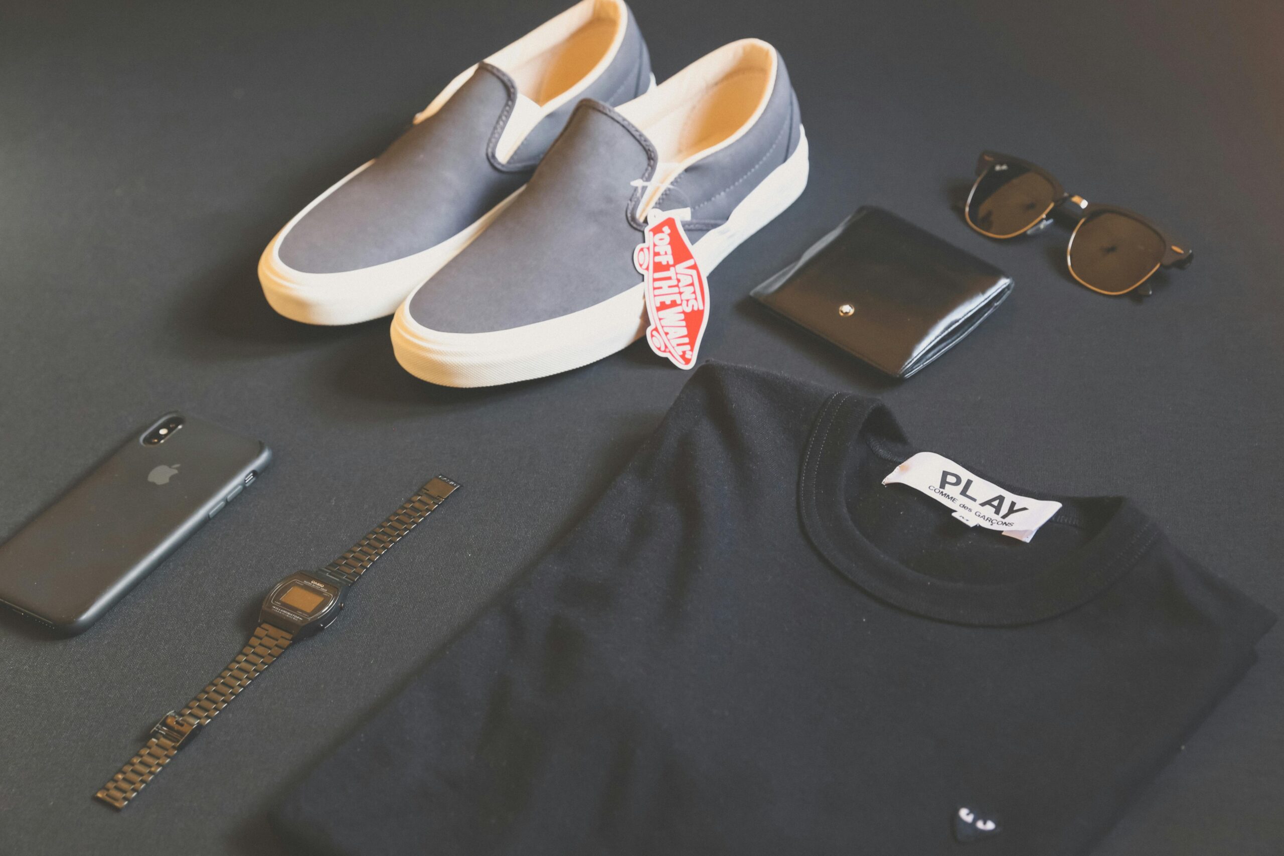 A modern collection of men's fashion essentials flat lay, featuring shoes, watch, phone, and eyewear for a sleek style.