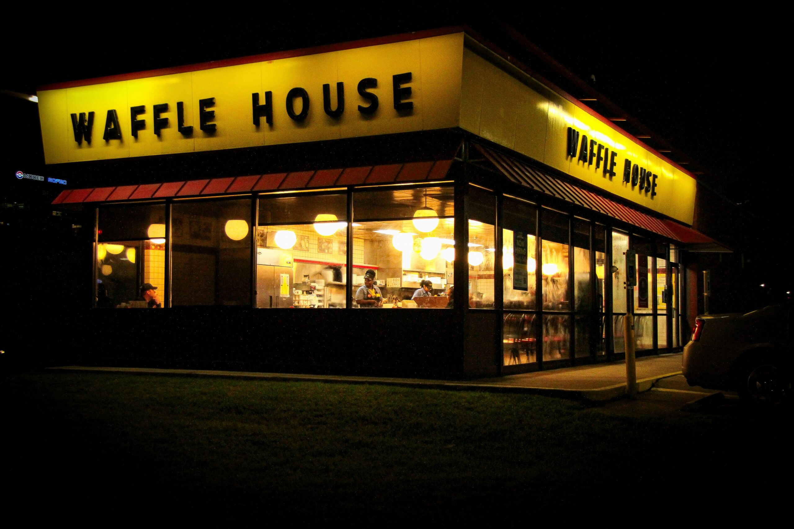 Evening view of Waffle House with bright lights in Houston, Texas.