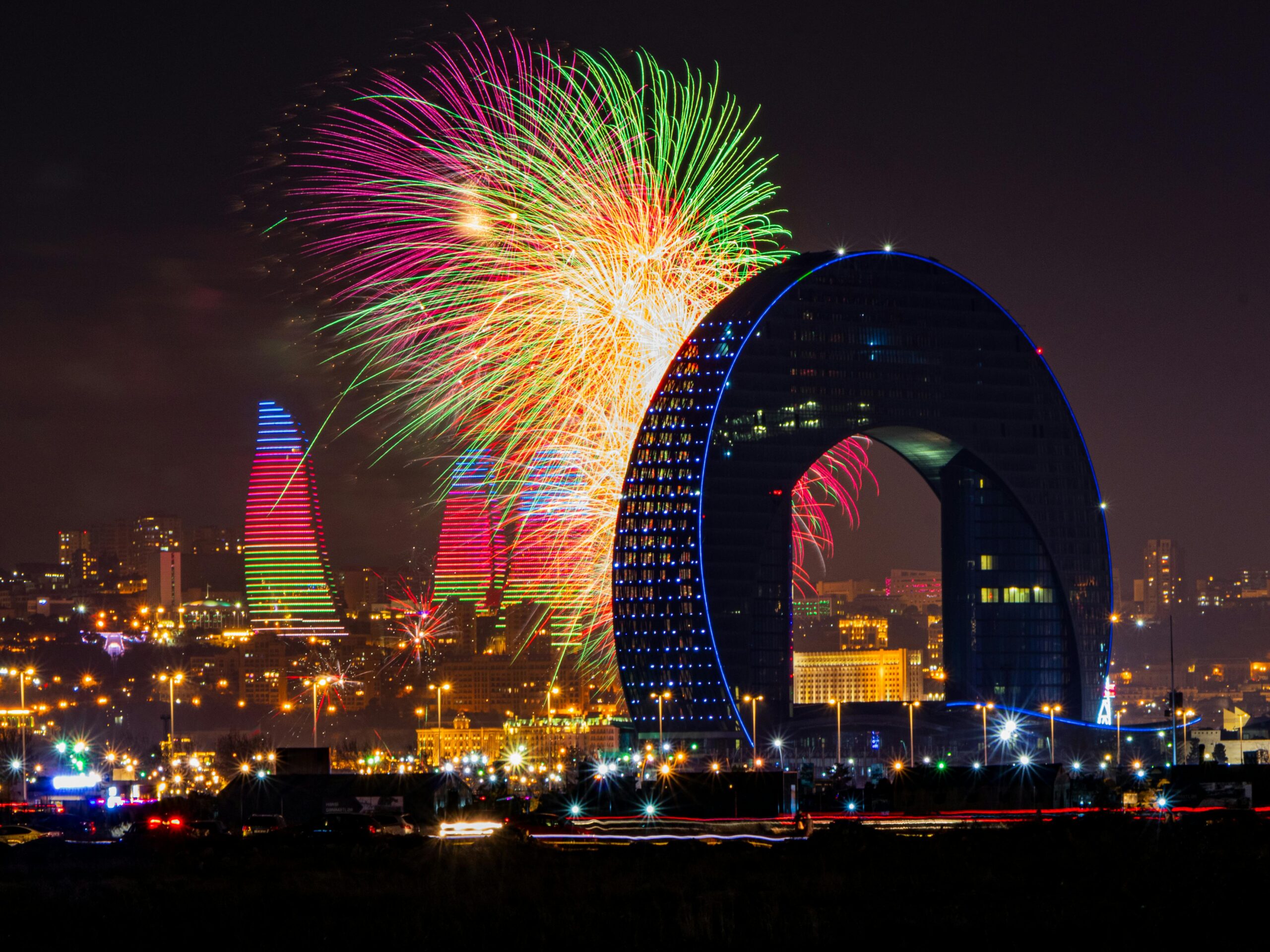 Stunning Baku cityscape illuminated by fireworks at night, featuring iconic Flame Towers.