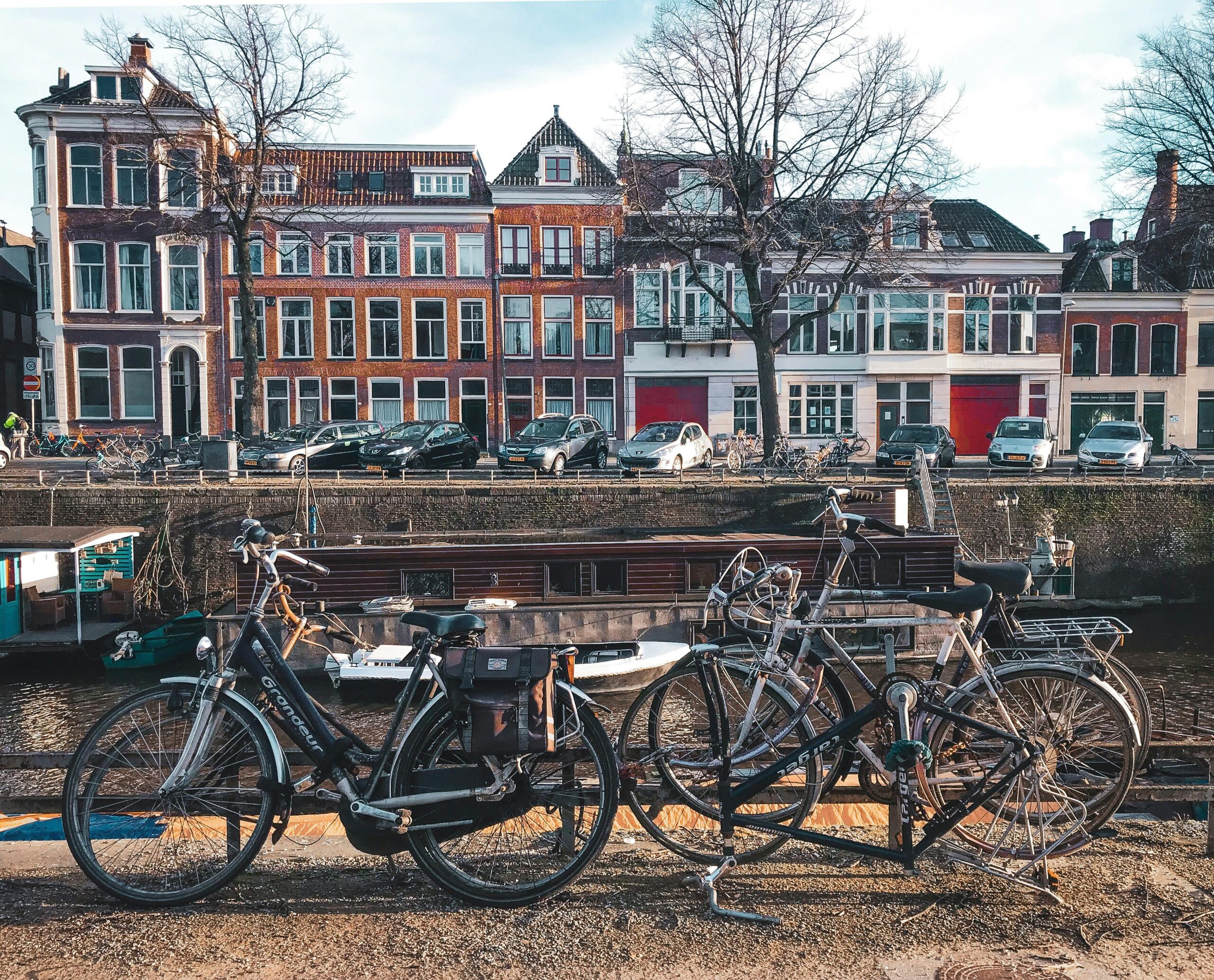 Picturesque street view of Groningen featuring bicycles, canal, and historic architecture on a sunny day.
