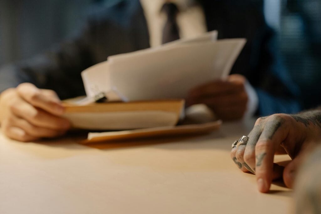 Close-up of business people reviewing documents at a desk, focused on hands and paperwork.