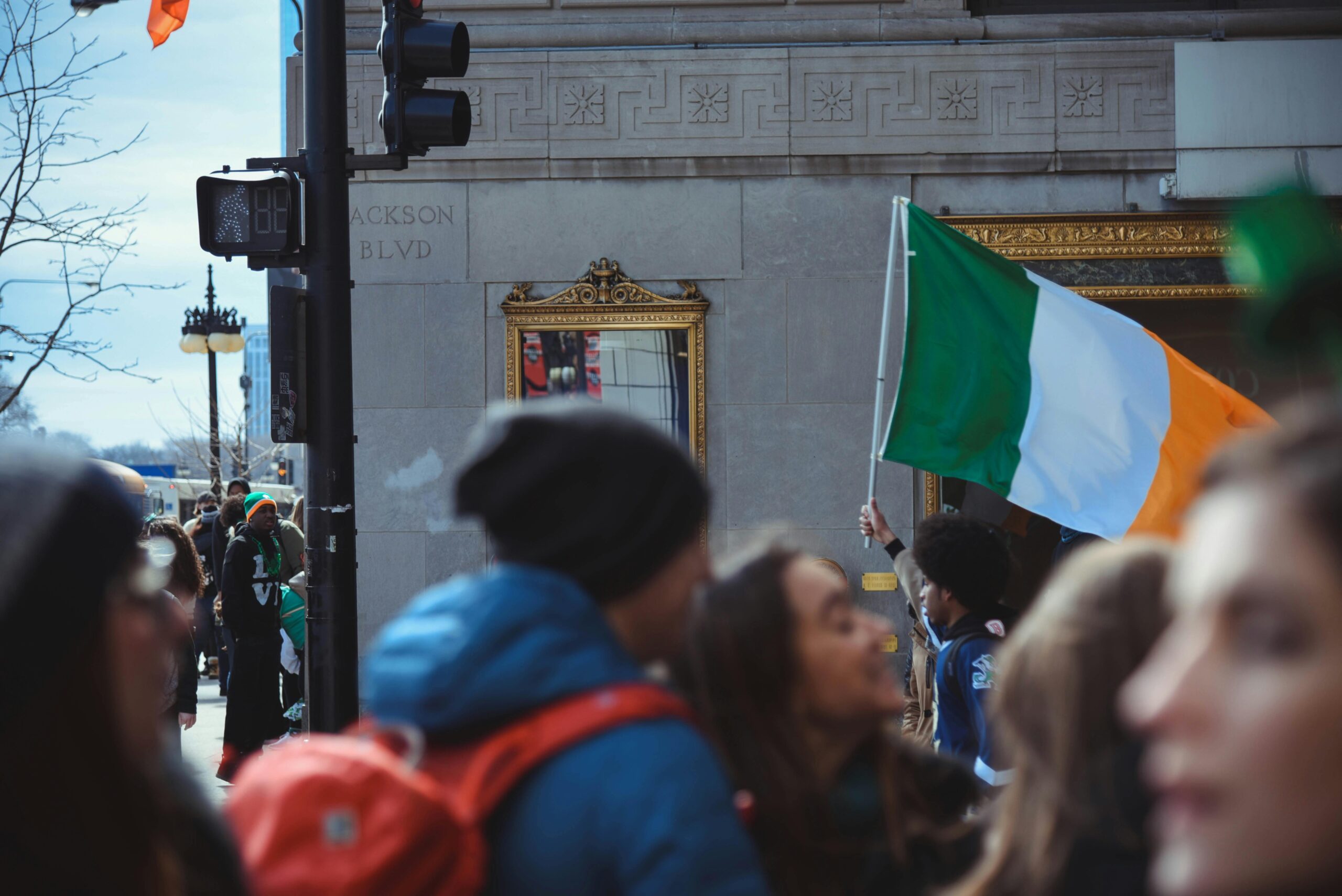 Crowd celebrates St. Patrick's Day in Chicago with Irish flags and festive atmosphere.