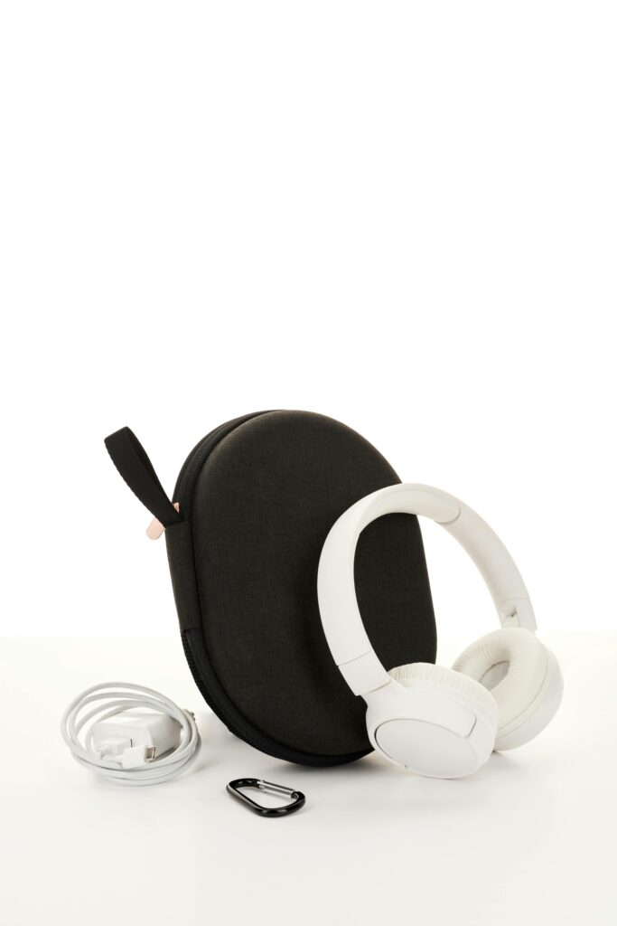 Sleek white wireless headphones with a travel case, cable, and clip, perfect for music on the go.