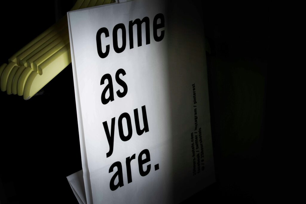 Minimalist image featuring a stylish quote about individuality with clothing hangers in the background.