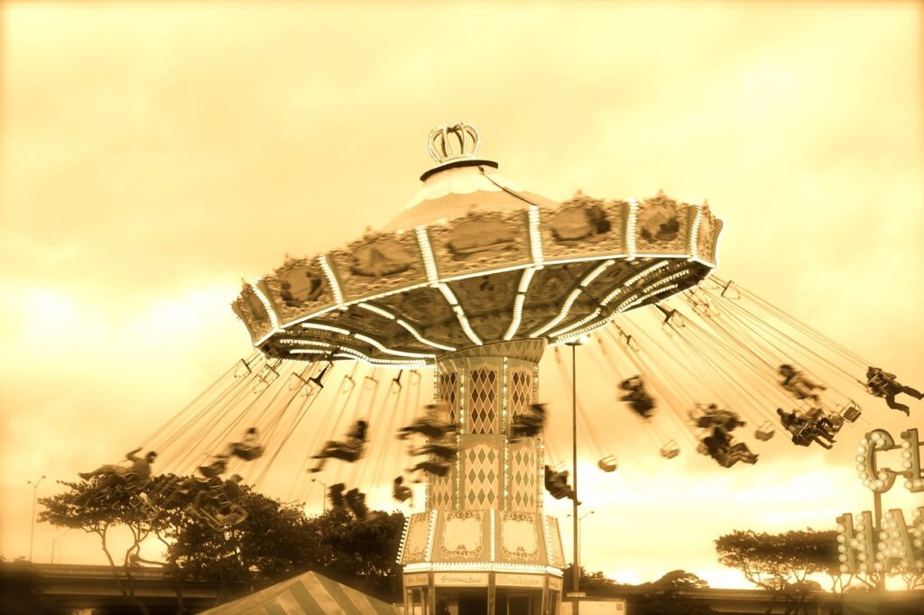swing, fair, carnival, ride, amusement, fun, park, funfair, leisure, child, festival, vacation, outdoors, happy, childhood, entertainment, summer, fairground, swinging, people, recreation, sky, joy, action, yellow sky, yellow happy, yellow summer, yellow park, yellow happiness, yellow fun