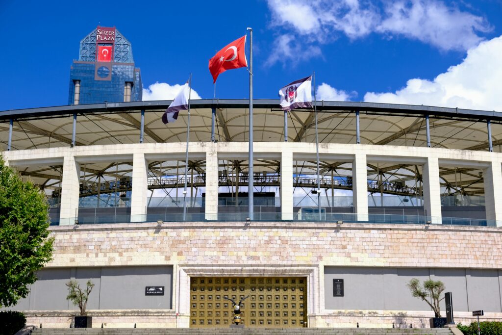 Bright daytime view of İstanbul's Süzer Plaza and stadium facade showcasing iconic architecture.