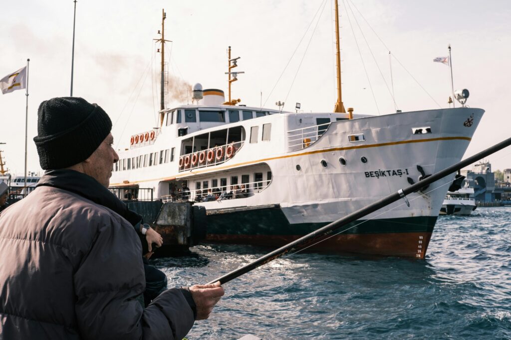 Elderly man fishing near the Beşiktaş ferry in Istanbul, Turkey.