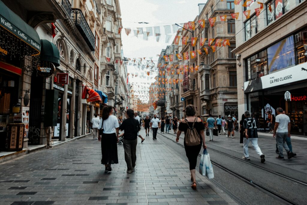 Vibrant street view of Istanbul's İstiklal Avenue with people shopping and walking.