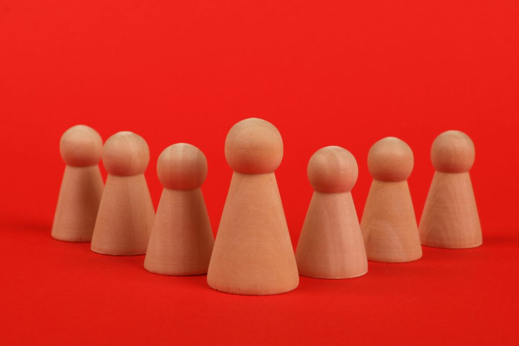 Close-up of crafted wooden figurines arranged on a vibrant red background.