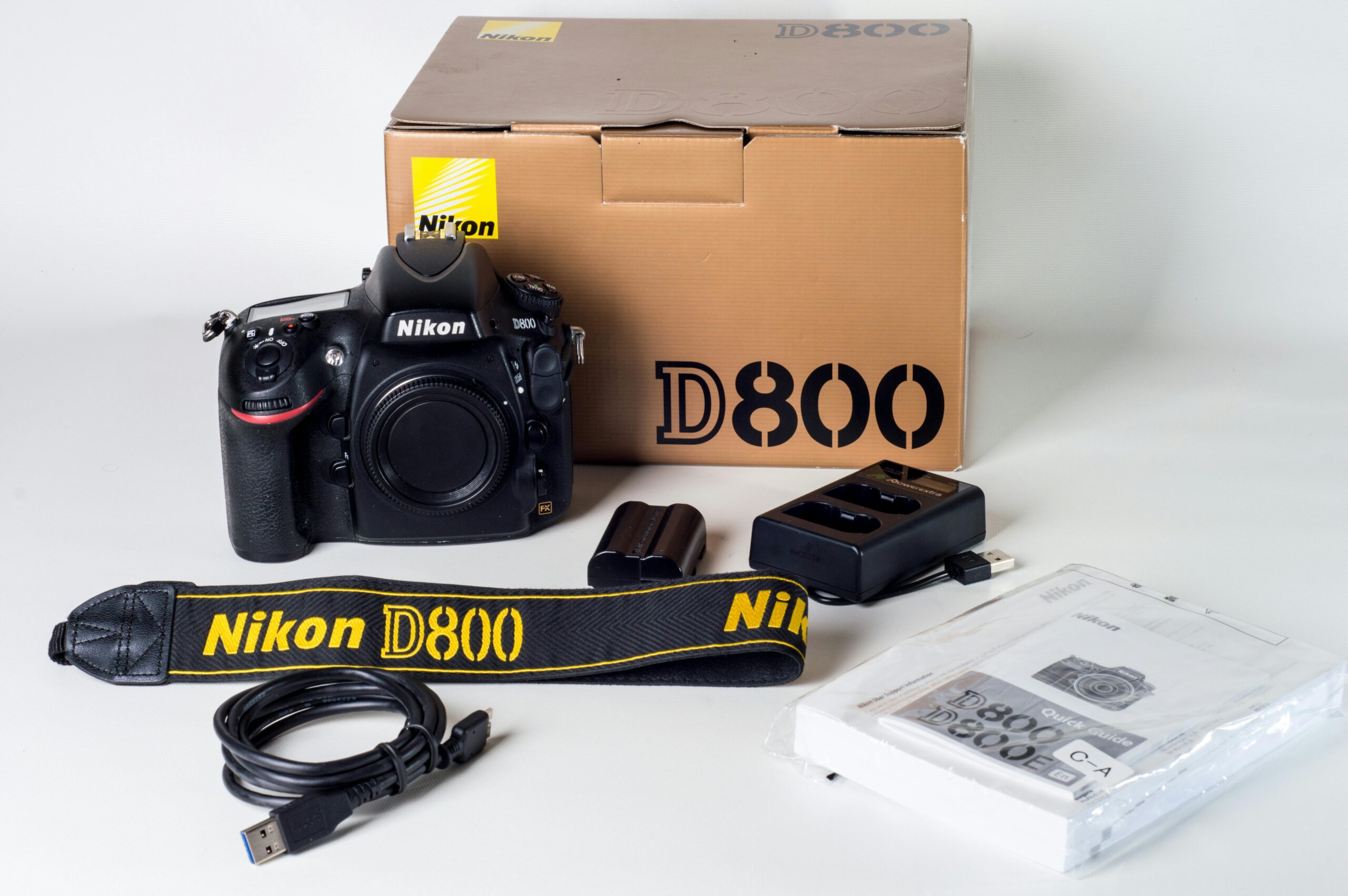 Nikon camera kit with accessories including strap, charger, and manual.
