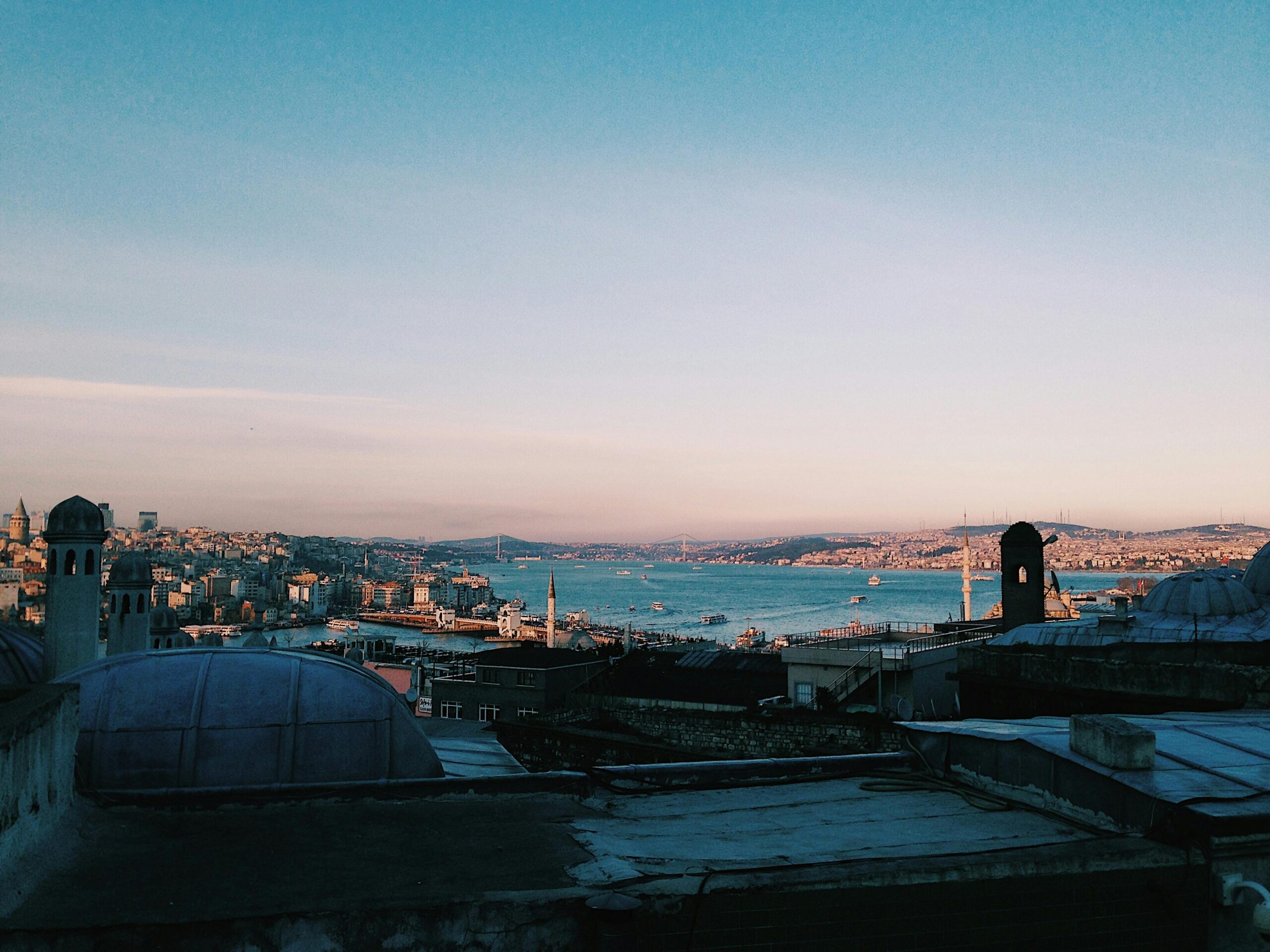 Capture of Istanbul cityscape with the Bosphorus, showcasing historic architecture and bustling waterways at sunset.