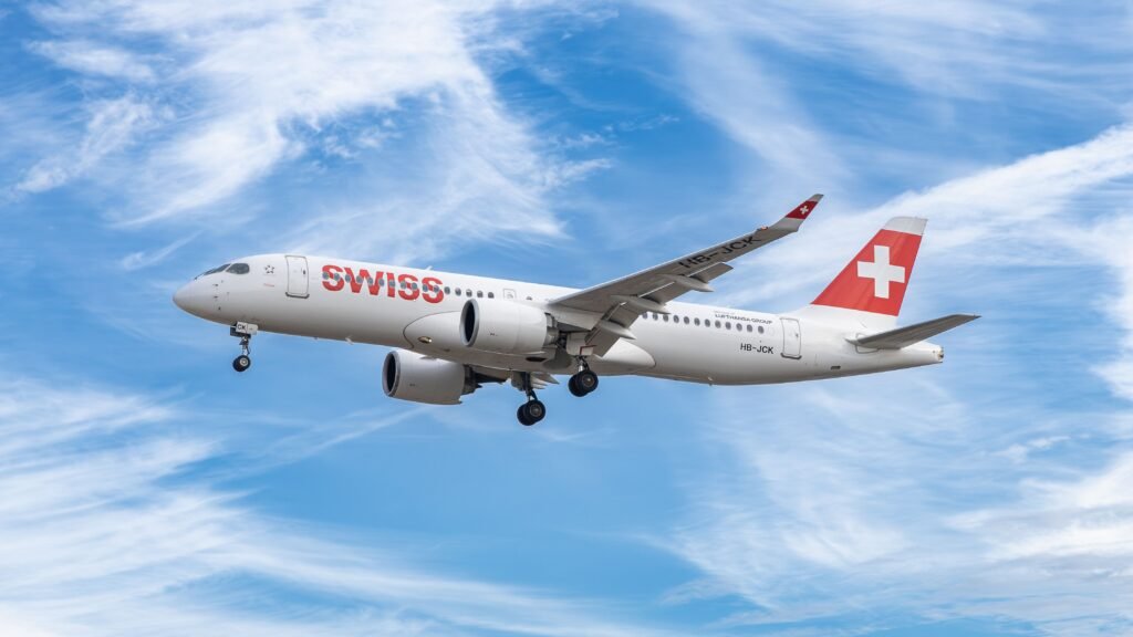 pexels-photo-39545120-39545120 A Swiss airplane in flight under a bright blue sky, showcasing modern aviation.