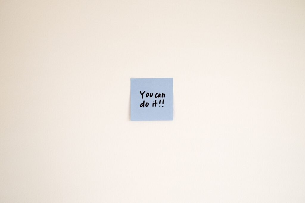 pexels-photo-29546585-29546585 A motivational message on a blue Post-it note reads 'You can do it!' on a cream wall.
