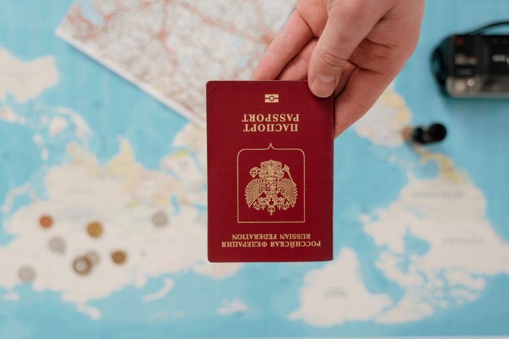 pexels-photo-7010170-7010170 A hand holding a Russian passport over a map, suggesting travel preparation.